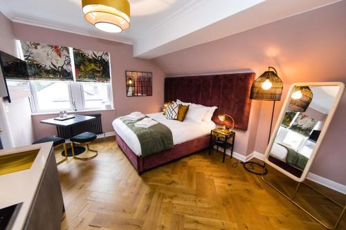 a hotel room with a bed and a mirror at Dragon Villas - Harrogate in Harrogate