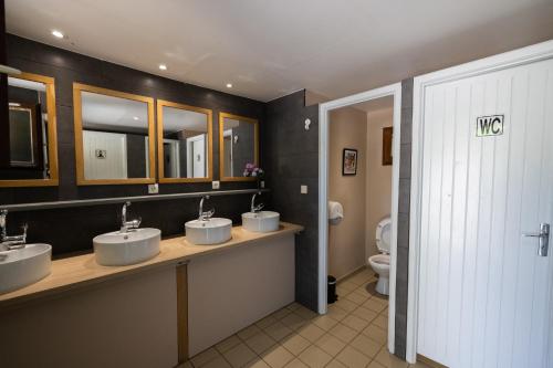 a bathroom with three sinks and a toilet at TENTE SAFARI Lodge FERME CARRIQUE in Tardets-Sorholus