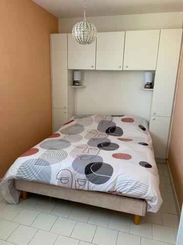 um quarto com uma cama com um edredão colorido em Appartement climatise - grande terrasse em Le Grau-du-Roi