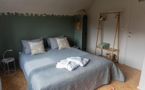 - une chambre avec un grand lit et des serviettes dans l'établissement Villa Plagniau, à Rixensart