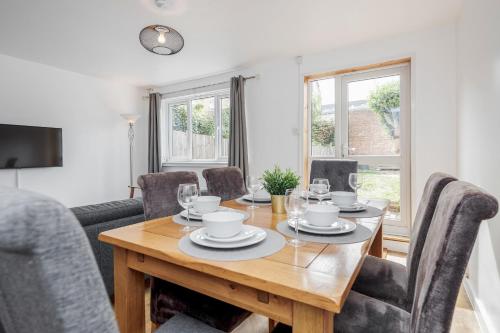 a dining room with a wooden table and chairs at Carlile House - London 5 bedroom Free Parking & Garden by Damask Homes in London