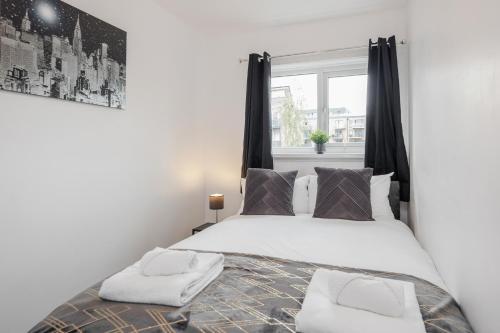 a bedroom with a large bed with a window at Carlile House - London 5 bedroom Free Parking & Garden by Damask Homes in London