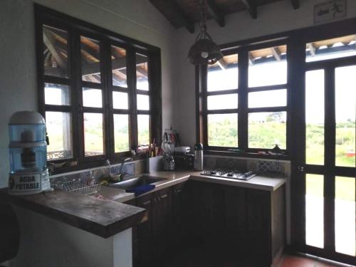 cocina con fregadero y encimera con ventanas en Casa Finca La Pintada en Montenegro