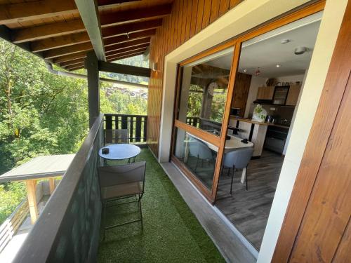 Cette maison dispose d'un balcon avec une table et des chaises. dans l'établissement Superbe studio de montagne entièrement rénové, à Morzine
