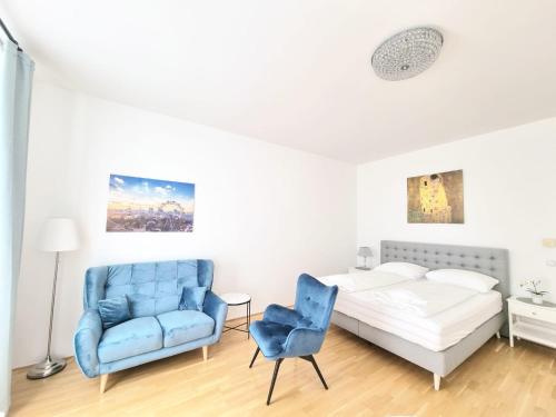 a bedroom with a bed and a blue chair at Herzlich Willkommen - Küss die Hand 4 in Vienna