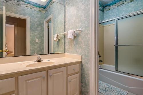 ein Badezimmer mit einem Waschbecken, einem Spiegel und einer Badewanne in der Unterkunft Dunes East - 330 Audubon Unit B home in Dauphin Island