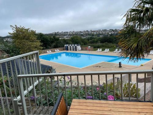 a large blue swimming pool with chairs and a wooden deck at G10 Hoburne Devon Bay pet friendly in Goodrington