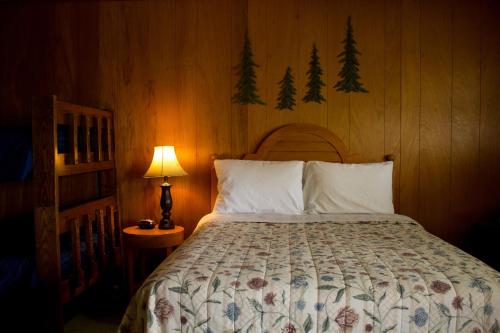 a bedroom with a bed with a wooden wall at Jimmy OConnor's Windham Mtn Inn in Windham