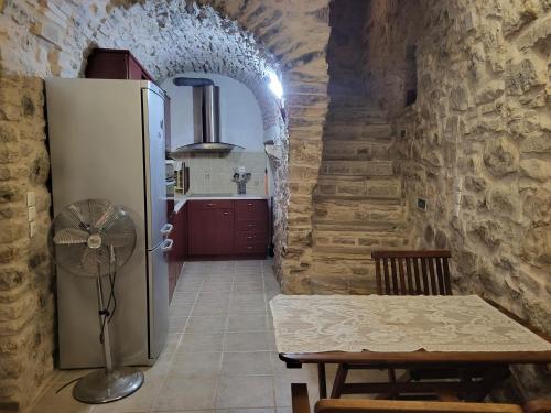 een keuken met een koelkast en een tafel in een kamer bij Traditional medieval Holiday House In Kalamoti in Kalamoti