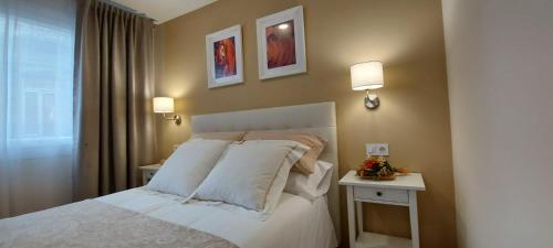1 dormitorio con 1 cama blanca con 2 mesas y 2 lámparas en Aires do Umia en Caldas de Reis