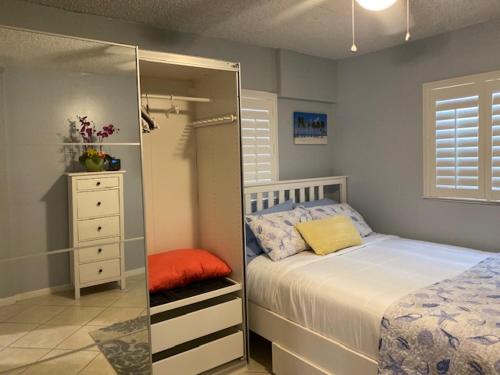 a bedroom with a bed and a dresser and a mirror at Modern 2/1 Apt near Midtown and Beaches in Miami