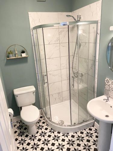 a bathroom with a shower and a toilet and a sink at Nidd House Apartment in Harrogate