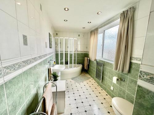 a bathroom with a sink and a toilet and a tub at 3 bedroom house with ample parking and garden 