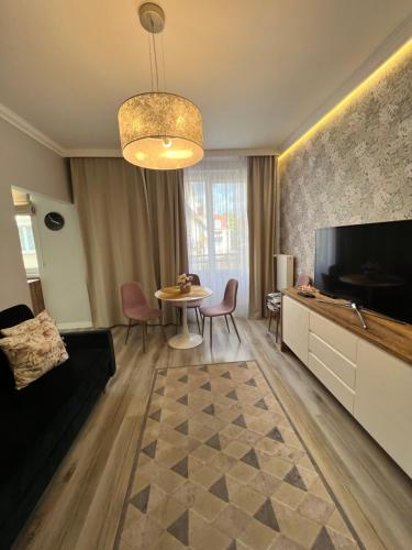 a living room with a television and a table with chairs at Apartament Wilkońskiego in Inowrocław