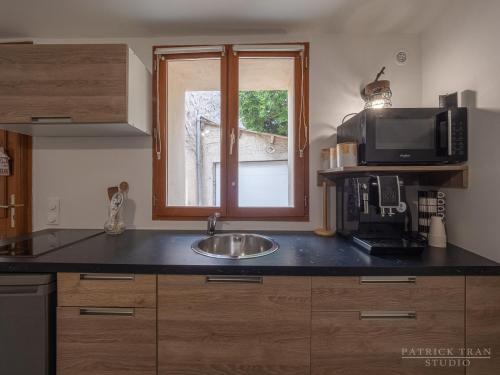 a kitchen with a sink and a microwave at Maison triplex 6 personnes près de Disney et Paris in Montévrain