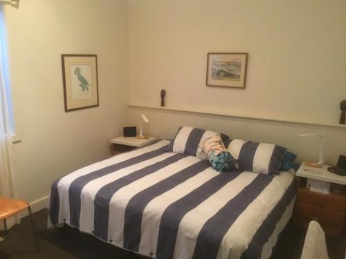 1 dormitorio con cama de rayas en blanco y negro en Kookaburra’s Rest, en Cams Wharf