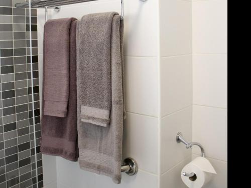 a bathroom with three towels hanging on a shower stall at Florida Ocean View Gigantes in Acantilado de los Gigantes