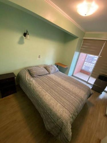 a bedroom with a bed in a room with a window at Rebeca Matte 650 a pasos del Principal Balneario in Antofagasta