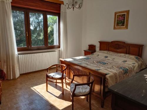 a bedroom with a bed with two chairs and a table at Appartamento doppi bagni sei posti letto in Viverone