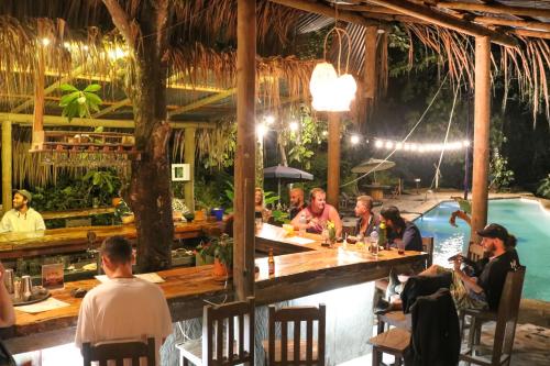 grupa ludzi siedzących w barze w restauracji w obiekcie Río Elemento w mieście Minca
