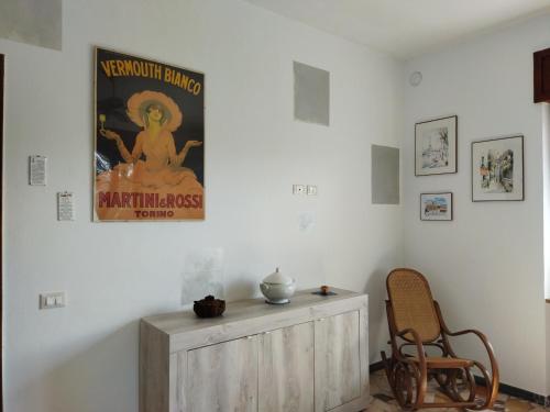 een kamer met een poster aan de muur en een stoel bij Appartamento doppi bagni sei posti letto in Viverone