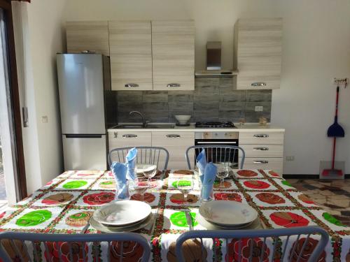 een keuken met een tafel met stoelen en een koelkast bij Appartamento doppi bagni sei posti letto in Viverone