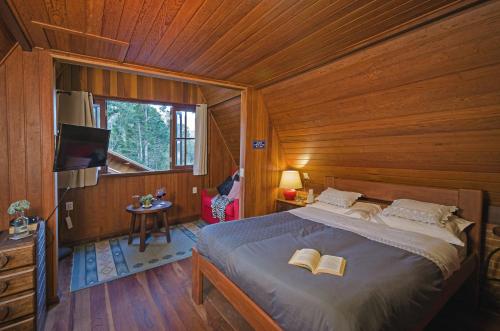 Un dormitorio con una cama con dos libros. en Chalé Pasárgada - Um pedacinho do paraíso na serra, en Bocaina de Minas