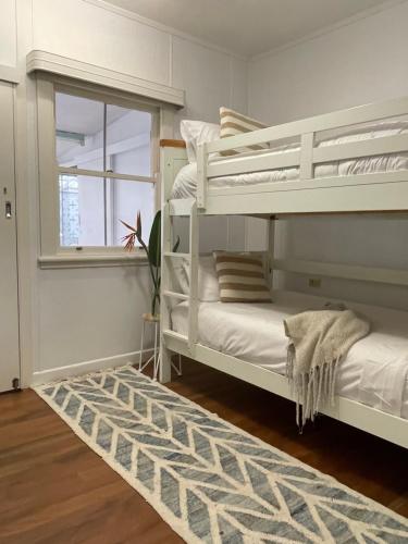 a bedroom with two bunk beds and a window at A Drop In The Ocean by Kingscliff Accommodation in Kingscliff