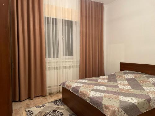 1 dormitorio con 1 cama y una ventana con cortinas en Stunning Lakeside Villa, en Korumdy