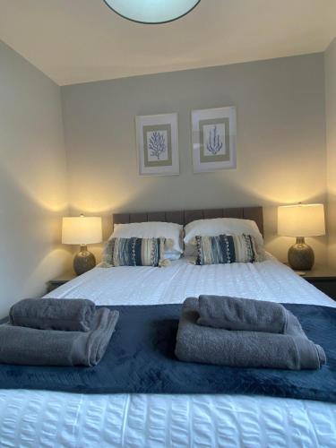 a bedroom with a large bed with two pillows on it at The Annexe Porthcawl Pet Friendly 2 Bedroom Flat with King Size bed bunk beds and sofa bed sleeps up to 5 people in Nottage