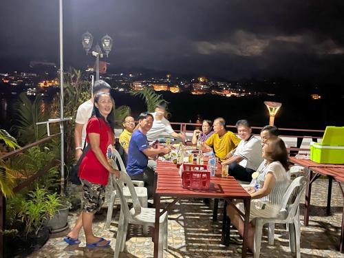 um grupo de pessoas sentadas em torno de uma mesa em um telhado em Day Waterfront Hotel em Chiang Khong