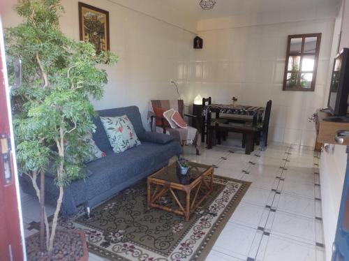 ein Wohnzimmer mit einem blauen Sofa und einem Tisch in der Unterkunft Pouso Ponte dos Suspiros com Garagem in Ouro Preto