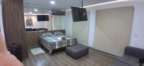 a bedroom with a bed and a living room at Confortável Loft em Santo Amaro -Alto da Boa Vista in Sao Paulo