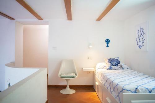 - une chambre avec un lit et une chaise dans l'établissement casa con vista panoramica, à Anacapri