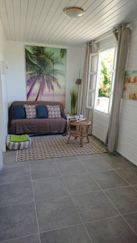 a living room with a couch and a table at Héritage créole 2 : Cirik in Sainte-Luce