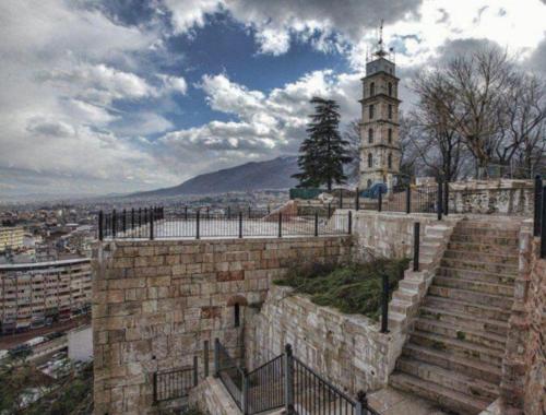 un edificio con una torre de reloj en una ciudad en Uraz Apart en Bursa