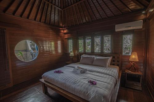 ein Schlafzimmer mit einem Bett mit lila Blumen darauf in der Unterkunft Panorama Cottages I in Legian