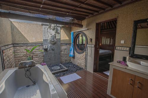 ein Badezimmer mit Badewanne und Waschbecken in der Unterkunft Panorama Cottages I in Legian