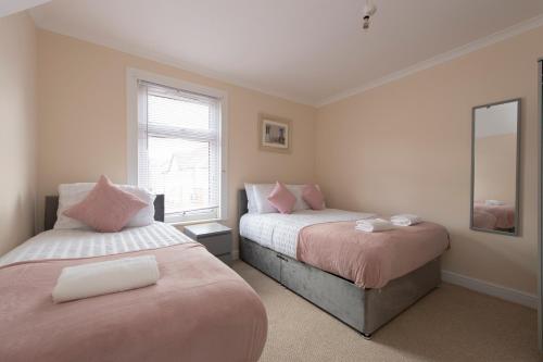 A bed or beds in a room at Beautiful 2 bed house in Grays 4 separate beds sleeps 5