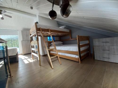 a room with two bunk beds and a staircase at Apartamento dúplex vacacional cerca a la playa in Gaira