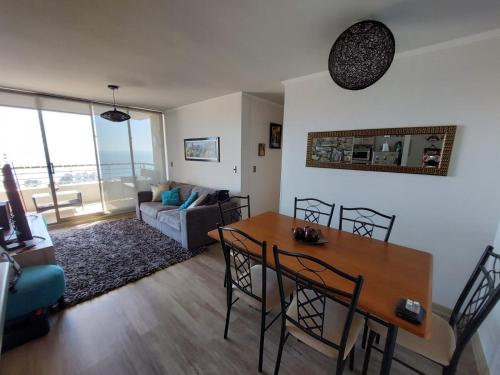 sala de estar con mesa y sofá en Departamento Concón Vista Montemar II en Concón