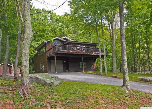 ein Haus mit einer Terrasse im Wald in der Unterkunft Mountaintop Lookout with Hot Tub under the Stars in Hunter