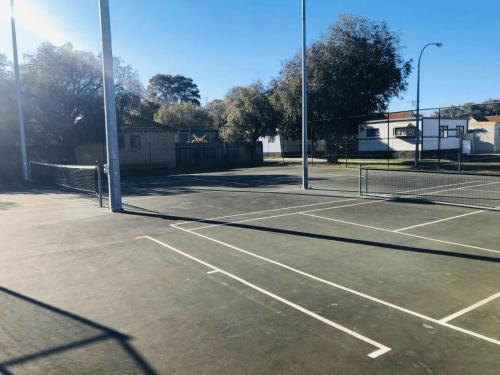 a tennis court with two tennis nets on it at Goin Coastal in Busselton