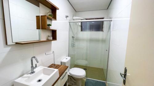 a bathroom with a shower and a toilet and a sink at Frente para o Mar com Vista Incrível - Porto1003 in Praia Grande