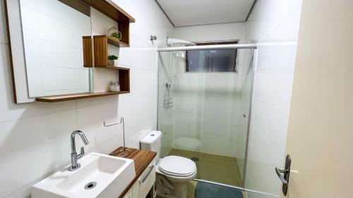 a bathroom with a shower and a toilet and a sink at Frente para o Mar com Vista Incrível - Porto1003 in Praia Grande