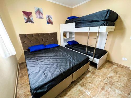 a bedroom with two bunk beds with blue pillows at Frente para o Mar com Vista Incrível - Porto1003 in Praia Grande