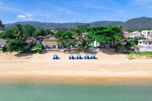 Baanfah Resort Samui في شاطئ مينام: إطلالة علوية على شاطئ به كراسي والمحيط