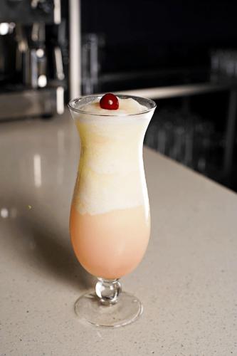 a drink in a glass with a cherry on top at Basha Hotel & Restaurant in San Pedro Sula