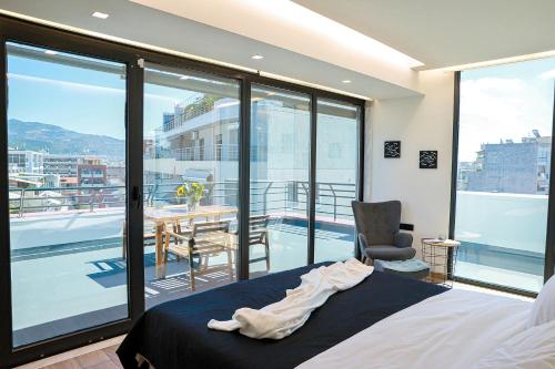a bedroom with a bed and a chair and a balcony at The First Key Luxury & small apartment in the center of Xanthi in Xanthi