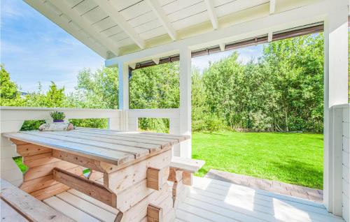 a porch with a wooden table and a large window at 1 Bedroom Amazing Home In Ustka in Ustka